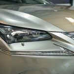 Detailed shot of a luxury car's headlight and front bumper.